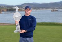 Rory McIlroy of Northern Ireland poses with the winner's trophy after winning the AT&T Pebble Beach